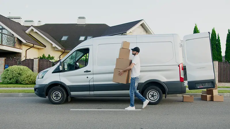 Man in white shirt carrying boxes for delivery