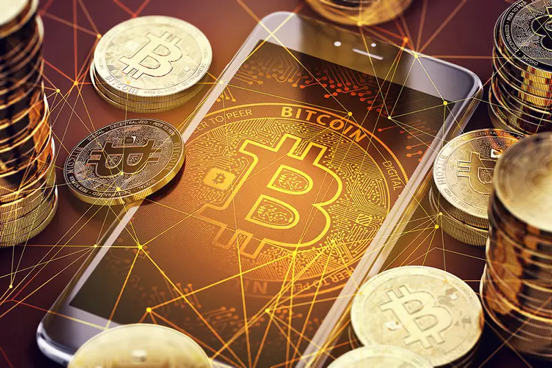 Smartphone with Bitcoin on-screen among piles of Bitcoins. Bitcoin in danger concept. 3D rendering