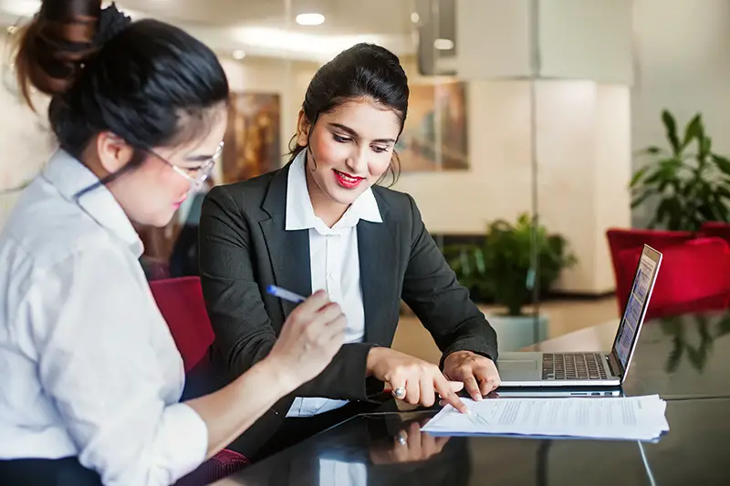 Indian female regional rural bank agent helping client sign the application document