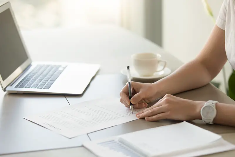 Businesswoman signing paper at workplace