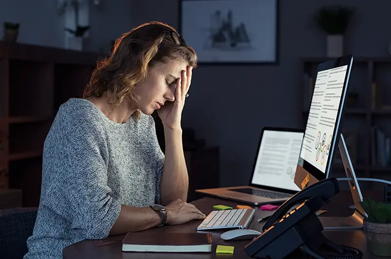 Tired woman working in the front of her computer