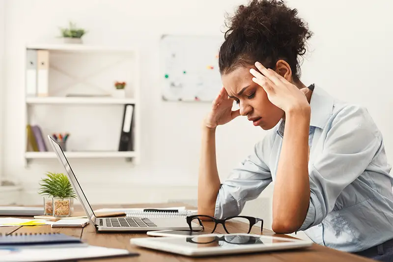 Tired african-american business woman with headache at office