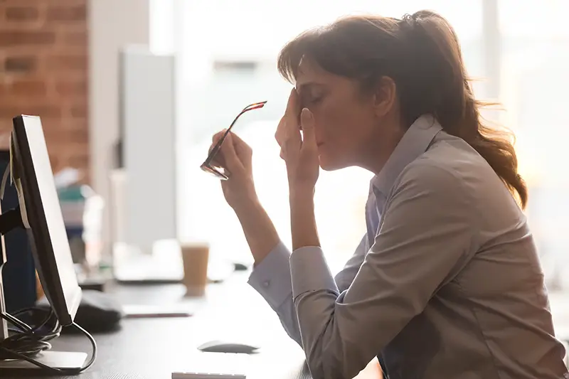 Exhausted female worker sit at office desk 