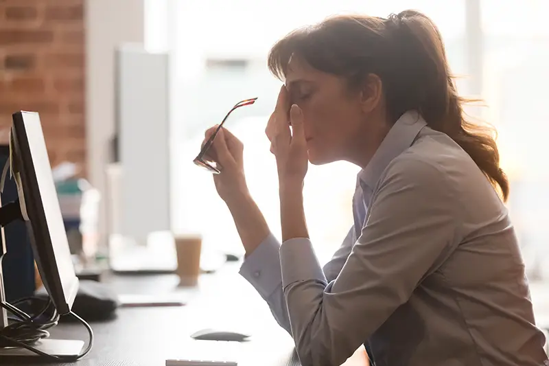 Exhausted female worker sit at office desk