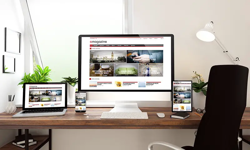 Web design on Computer and laptop screen on the top of wooden table