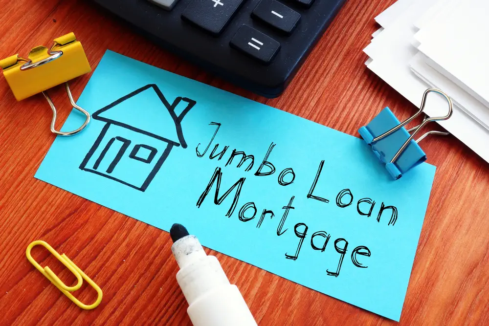 the words jumbo loan mortgage written on blue paper next to drawing of a house