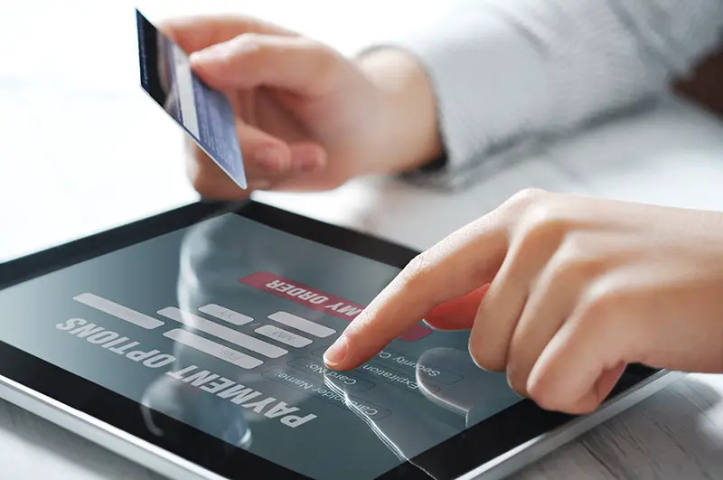 Female hands using touch screen device for online payment