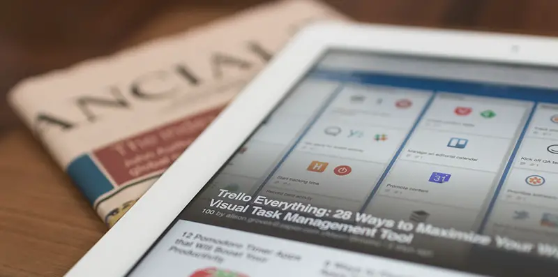 White tablet computer on the top of newspaper