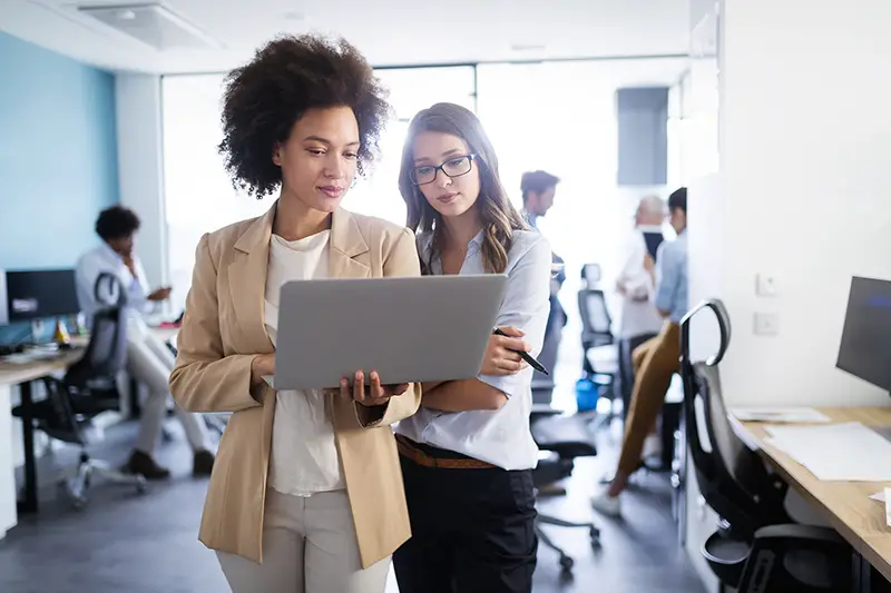 Two business women checking on the laptop