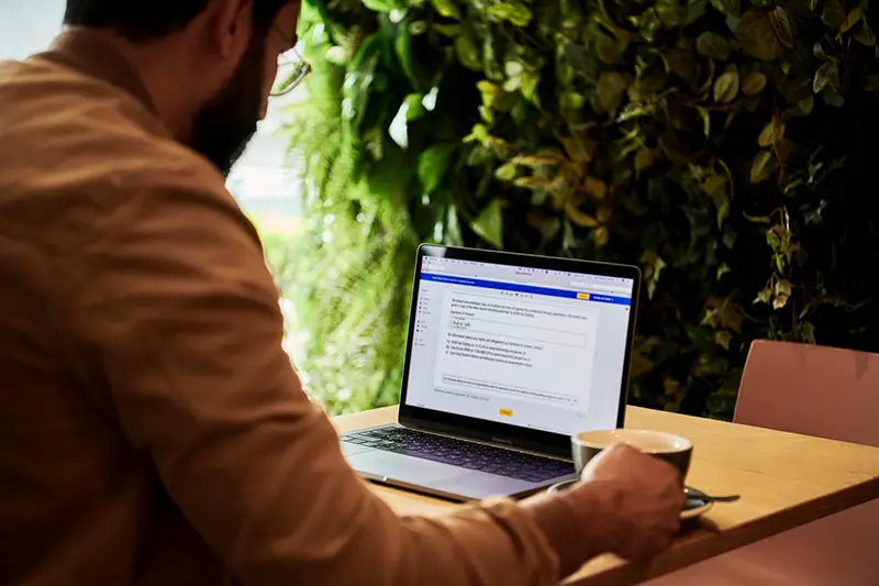 Man in brown jacket working on his laptop