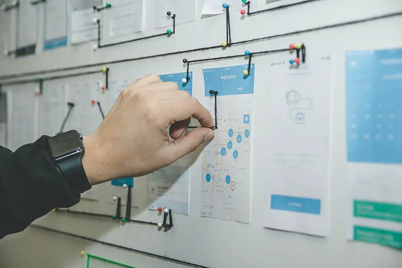 Person working on blue and white paper on board