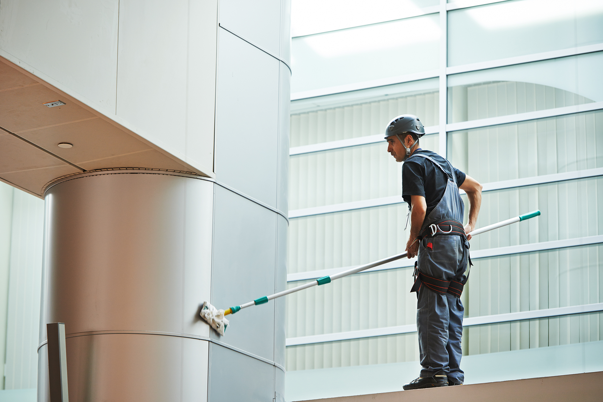 Man cleaning the wall inside the building