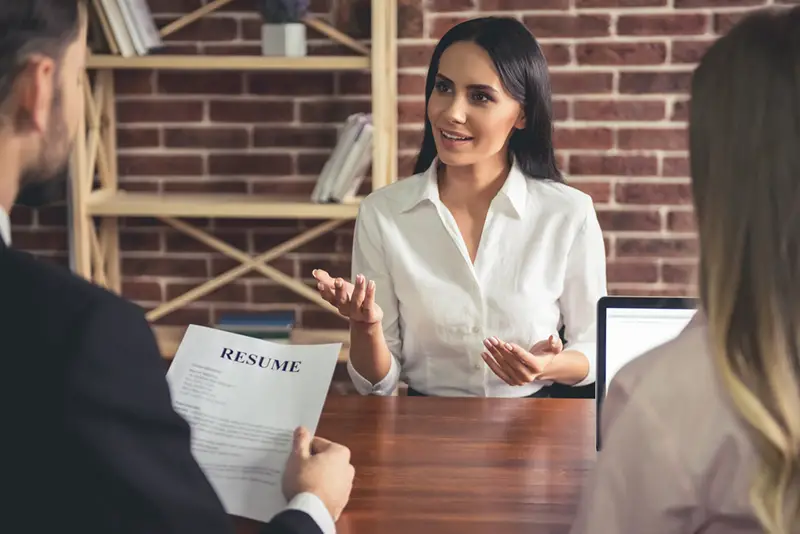 Woman in front of two interviewer