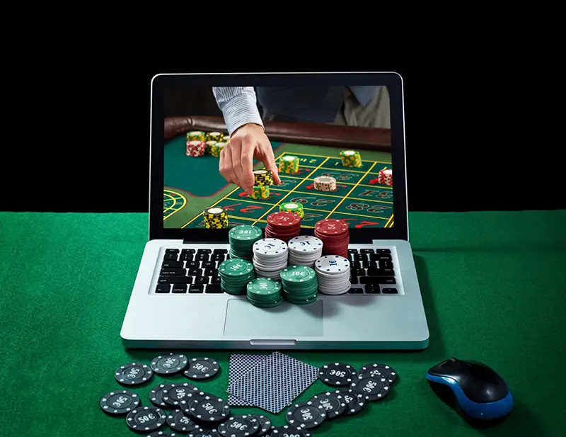 Man holding tokens on the top of laptop