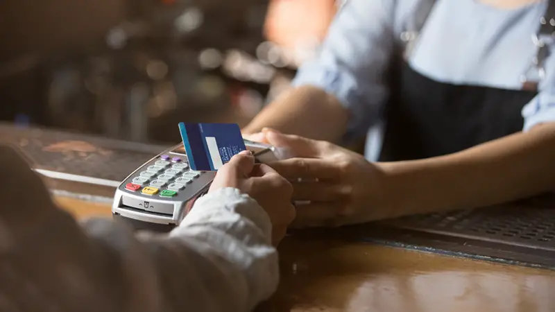 Contactless payment concept, female customer holding credit card near nfc technology on counter, client make transaction pay bill on terminal rfid cashier machine in restaurant store, close up view