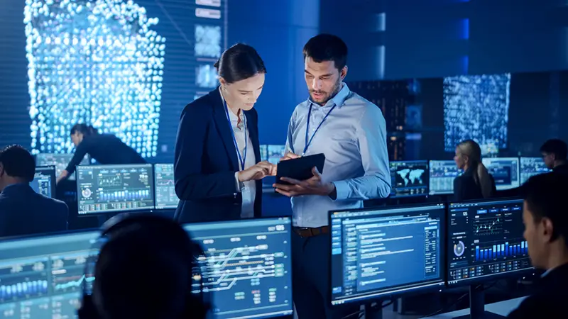 Project Manager and IT support Engineer Talking while Using A Digital Tablet Computer