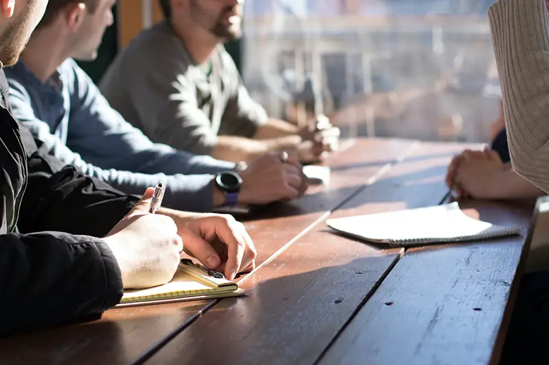 People sitting on chair in front of wooden table