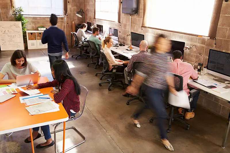 Elevated View Of Workers In Busy Modern Design Office