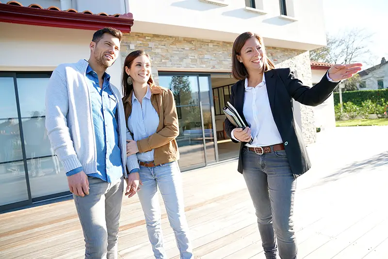 Couple with real-estate agent visiting house for sale