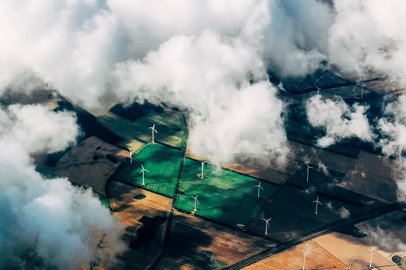 aerial view of windfarm through the clouds - green energy