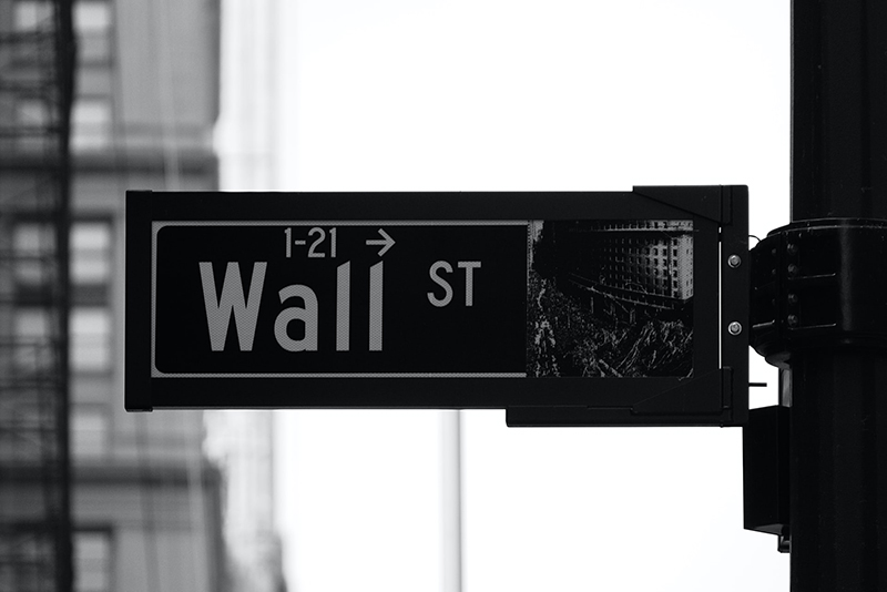 greyscale phot of Wall St. sign