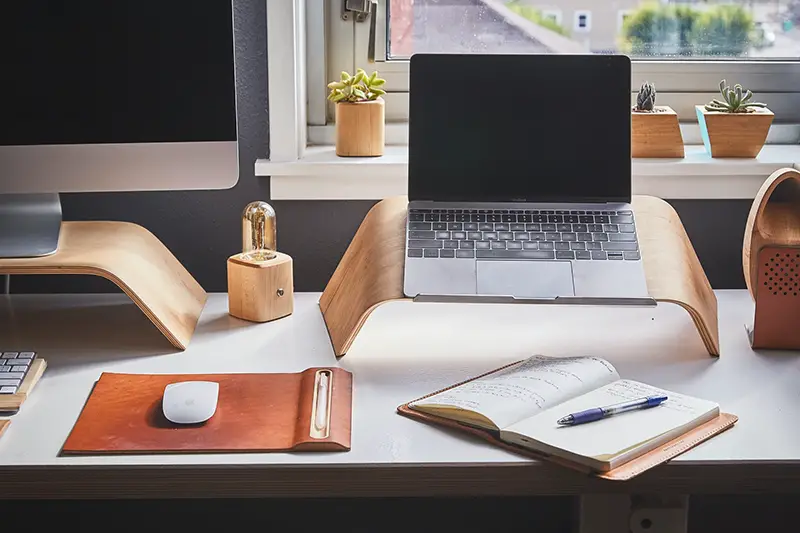 Black and silver laptop on brown wooden rack