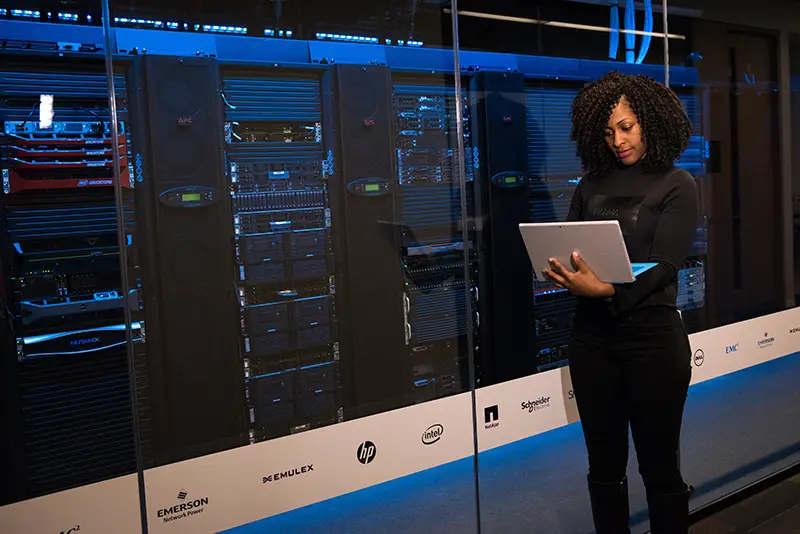 woman standing outside the server room holding a laptop