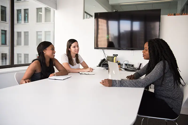 Three woman sitting at the table while doing job interview