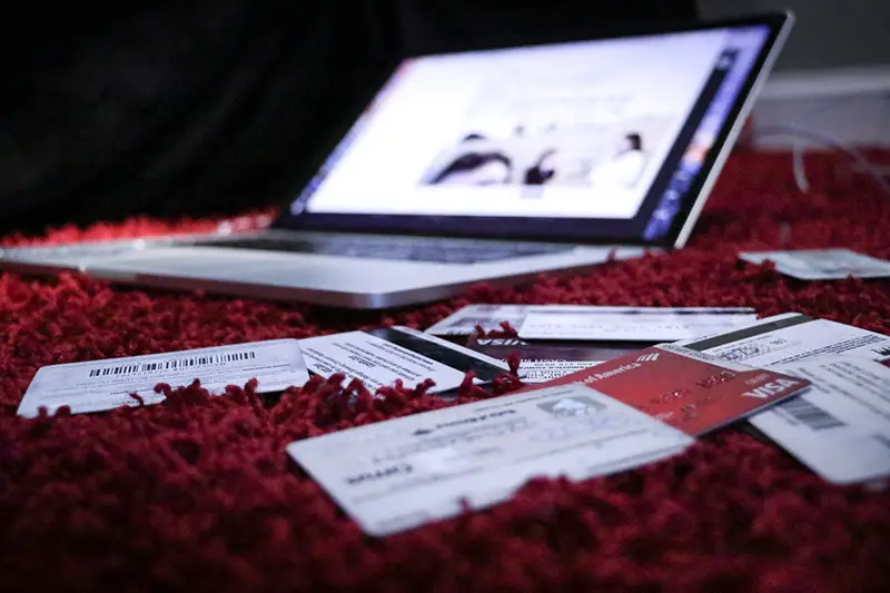 Laptop and credit cards on red textile