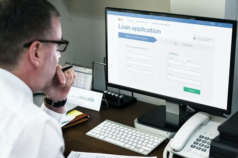 Businessman applying for an online loan on a computer