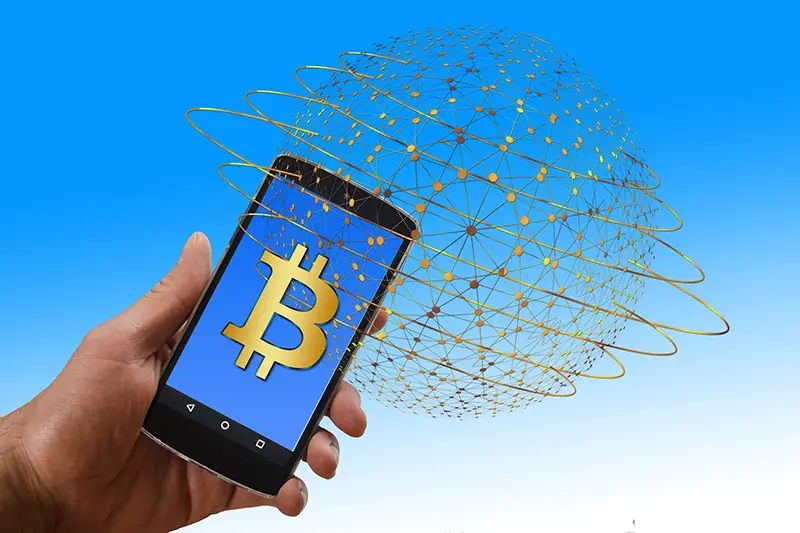 person holding smartphone with bitcoin symbol on the screen