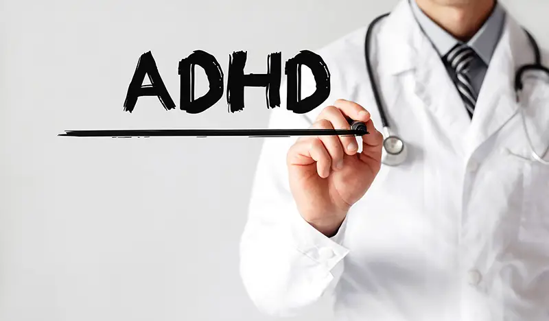Doctor writing word ADHD with marker