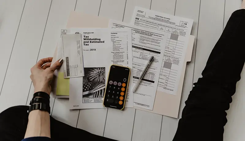 Person sittingon the floor assessing financial statements and receipts