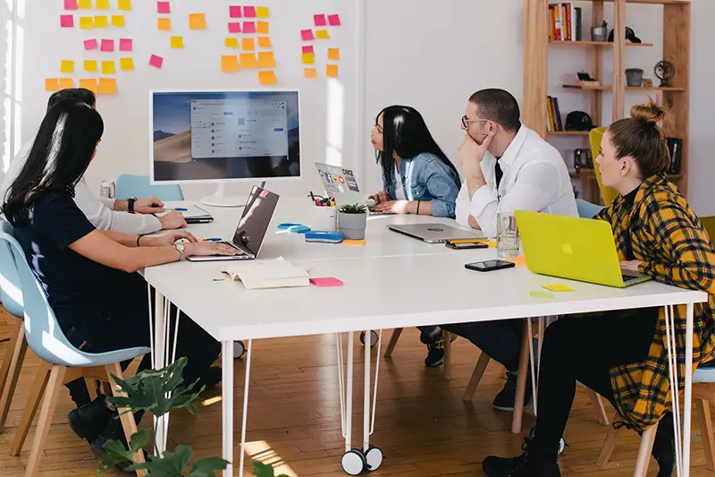 Five person watching turned on screen near white table