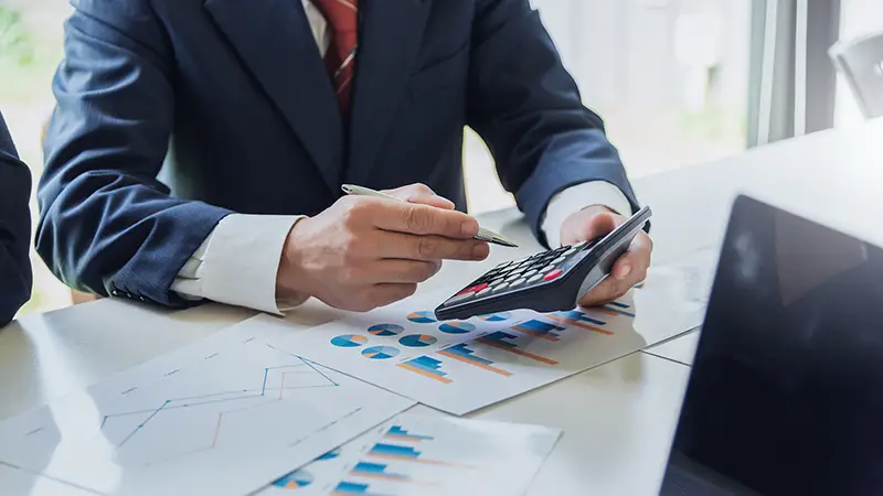 Businessman holding pen and calculator