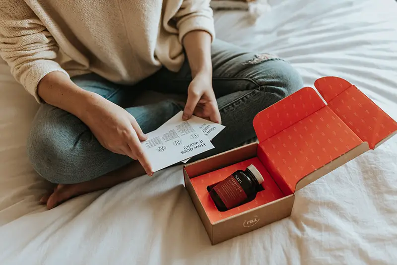 Red-labeled amber glass tub on a box