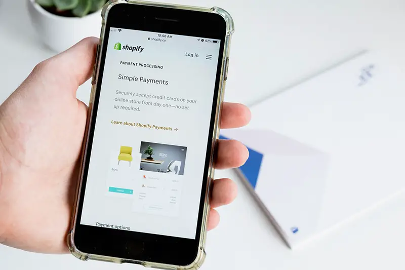 Person holding smartphone with shopify apps on the screen