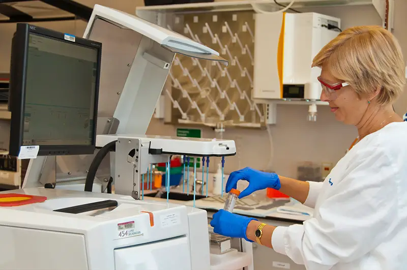 Woman in white medical scrub suit working in a laboratory