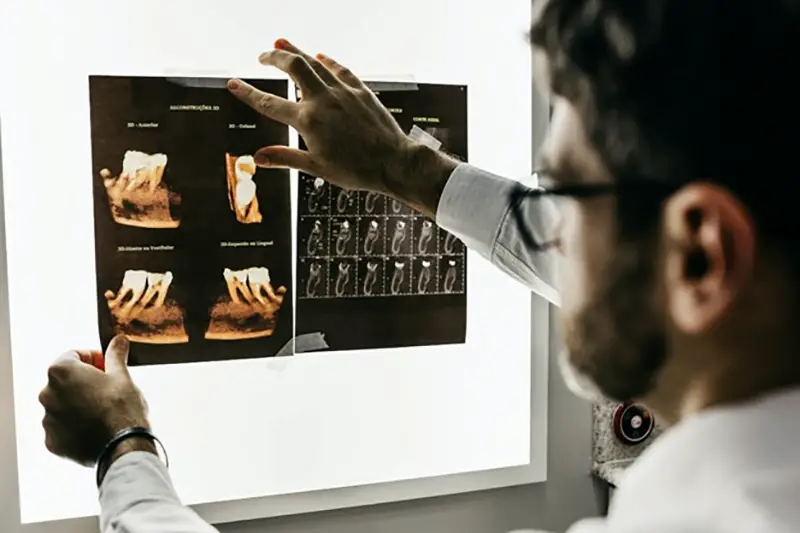 Male dentist holding x-ray of dental