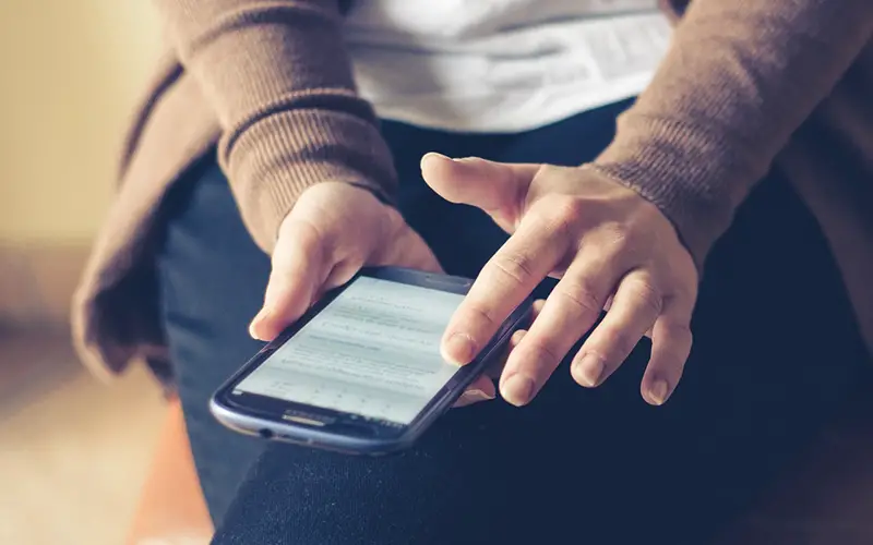 Person holding smartphone while sitting