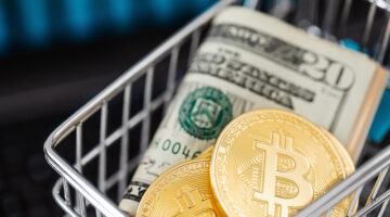 Bitcoin cryptocurrency in mini shopping trolley with dollar bills