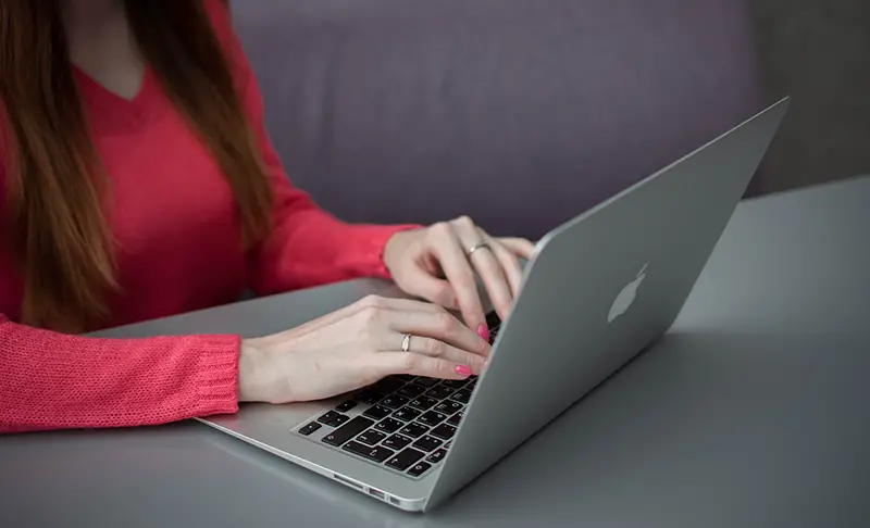 Woman in red using macbook computer