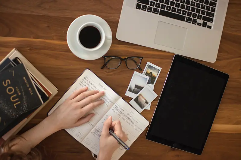 Person holding pen writing on notebook