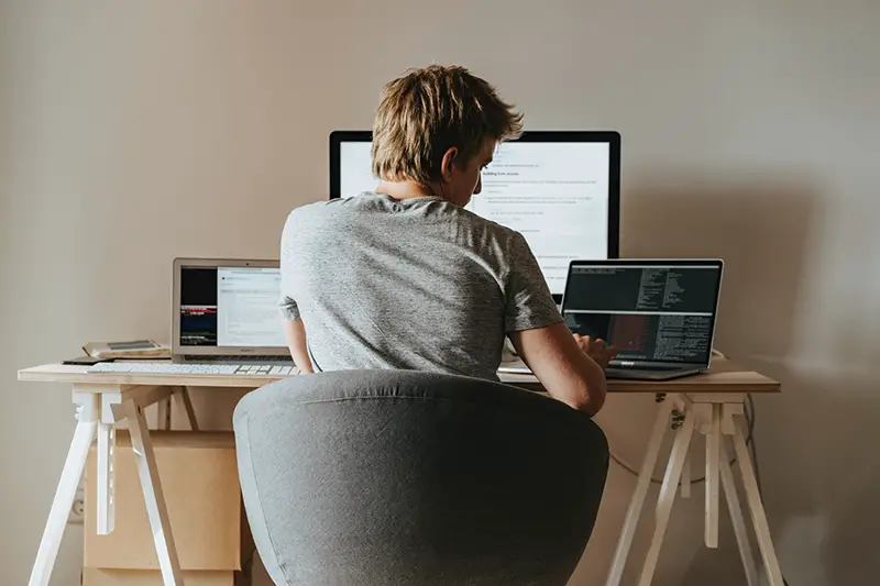 Man working from home sitting in front of his desk and laptop