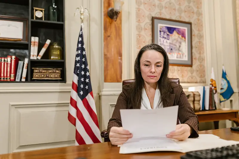 Woman lawyer reading documents sitting inside lawyer office