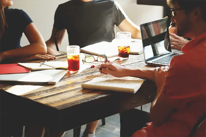 Group of people talking around brown wooden table