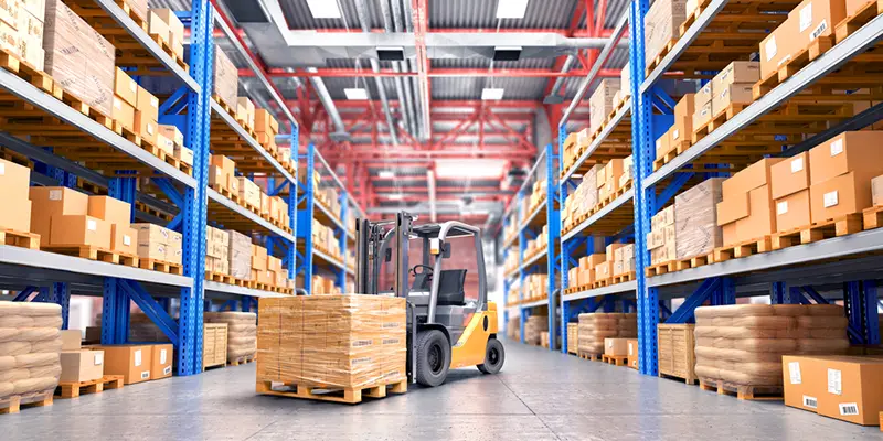 The forklift between rows in the big warehouse.