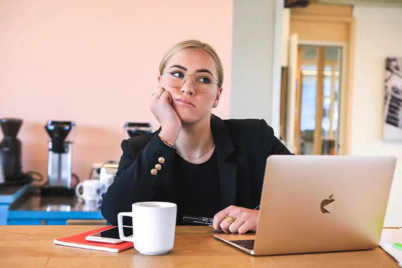 Woman bored and tired in fron t of her laptop