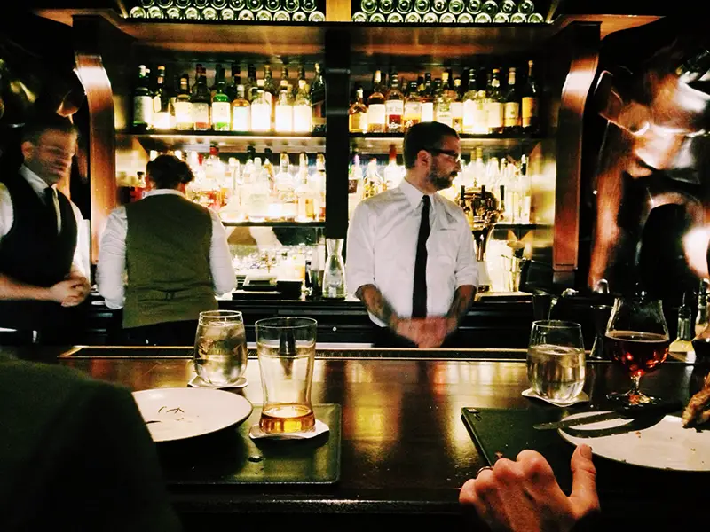 Bartender standing beside table