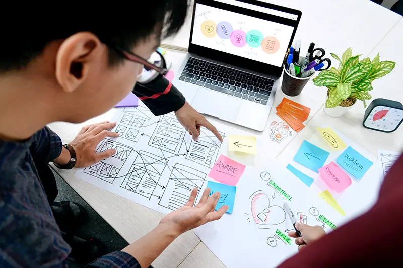 group of people planning with sticky notes and laptop on the table